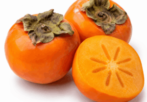 Ripe orange kaki persimmon fruits with one fruit sliced open