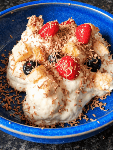 Creamy banana pudding recipe with berries, Swiss roll and grated chocolate