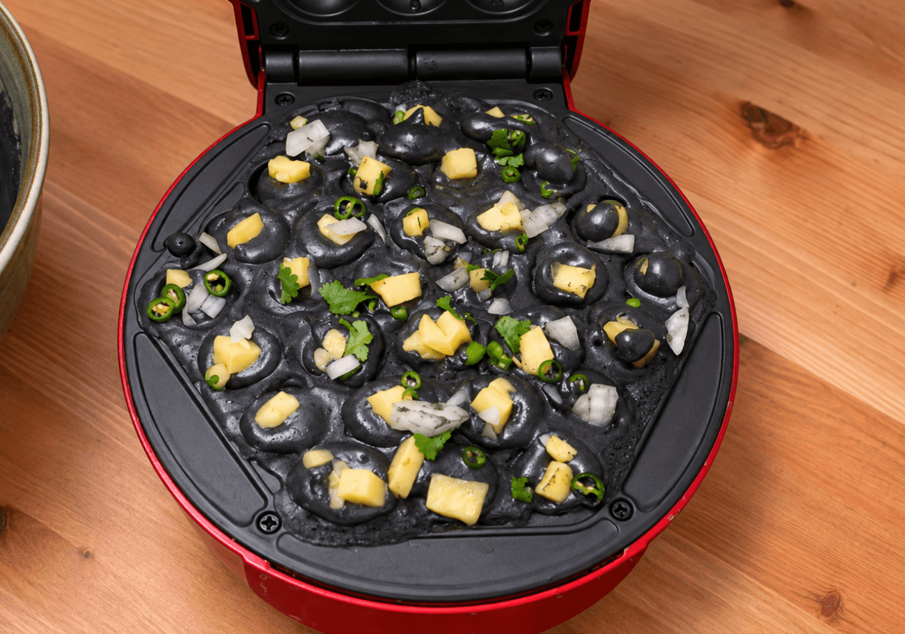 Black bubble waffle dosa filled with cheese onion and green chilli