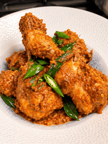 Chicken drumstick coconut masala garnished with curry leaves and green chilli