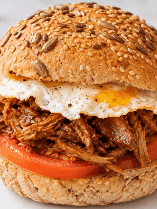 Leftover duck breakfast sandwich with fried egg tomato and seeded bread