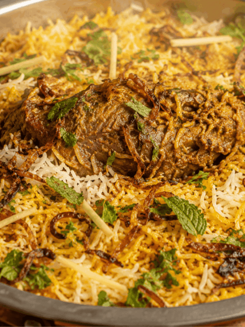 Lamb shank biryani with basmati rice, fried onions and mint