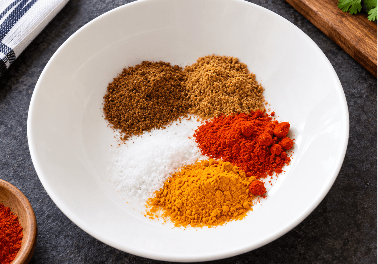 Bowl of tandoori spice mix with turmeric, red chili powder, salt, coriander powder, and garam masala.